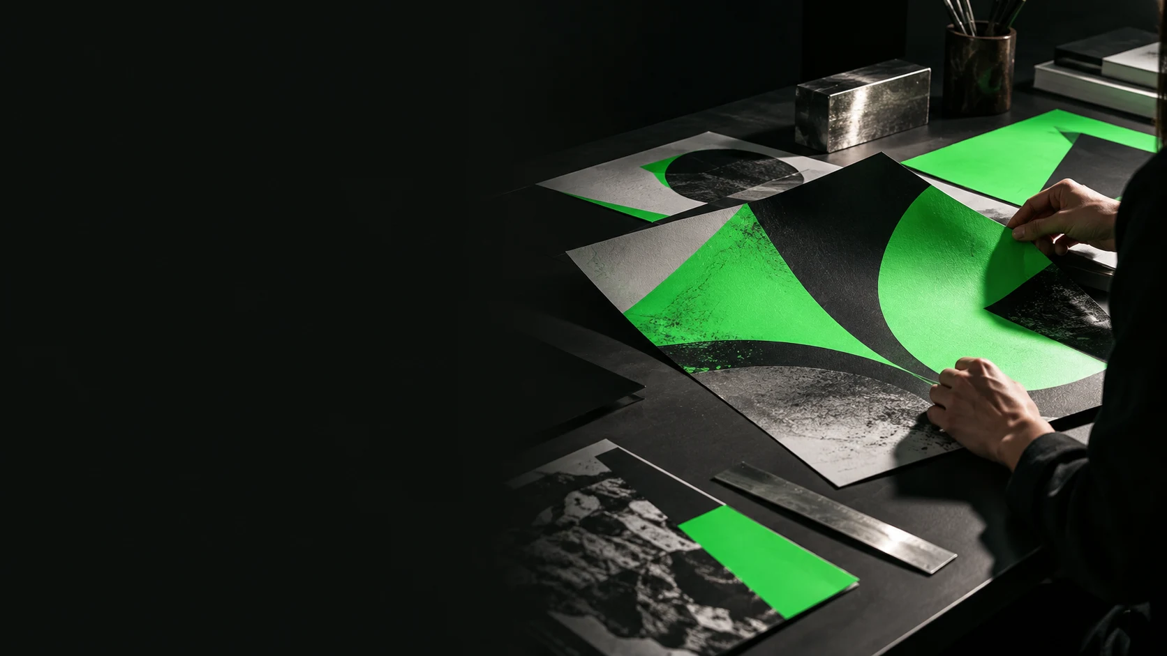 Dirección de arte: manos trabajando con composiciones gráficas verdes y negras